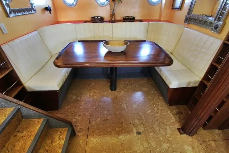 Ocean Villa Yacht Photos Pics Luxurious dining area in 1991 Custom Centre Cockpit Pilot House Motorsailer, featuring elegant wood table.