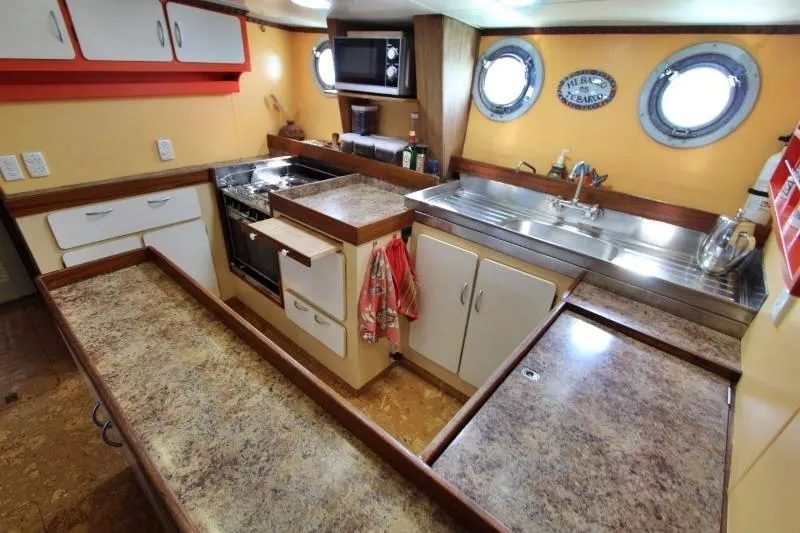 Ocean Villa Yacht Photos Pics Centre cockpit pilot house kitchen with portholes, stove, and ample counter space, 1991 motorsailer.