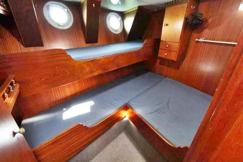 Ocean Villa Yacht Photos Pics Interior of 1991 Custom Centre Cockpit Pilot House Motorsailer with wooden bunk beds and portholes.