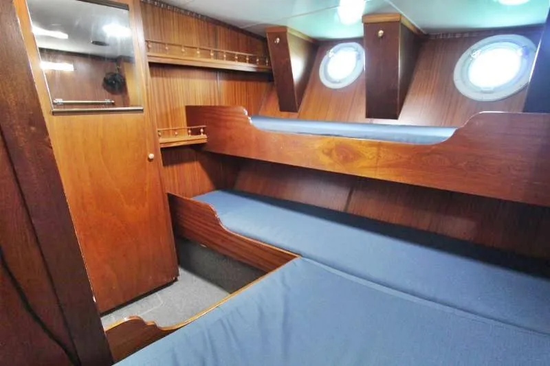 Ocean Villa Yacht Photos Pics Interior of 1991 Custom Centre Cockpit Pilot House Motorsailer with wooden bunk beds and portholes.