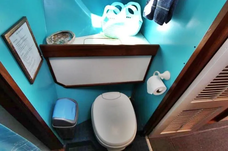 Ocean Villa Yacht Photos Pics Compact bathroom in 1991 Custom Centre Cockpit Pilot House Motorsailer, featuring toilet and storage.