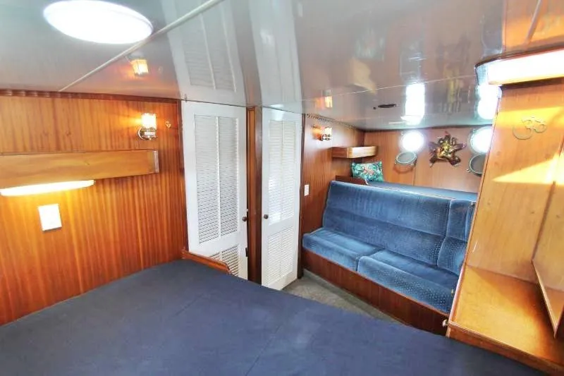 Ocean Villa Yacht Photos Pics Interior of 1991 Custom Centre Cockpit Pilot House Motorsailer with wood paneling and blue seating.