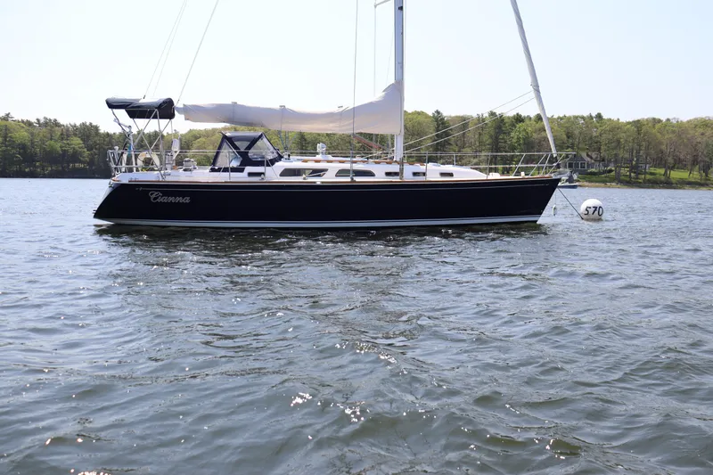 Cianna Yacht Photos Pics 2001 Sabre 402 sailboat on calm water with forested shoreline in background.