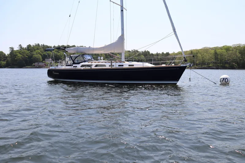 Cianna Yacht Photos Pics Sailboat Sabre 402, 2001 model, anchored on calm water with scenic background.