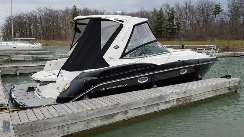  Yacht Photos Pics 2013 Monterey 340 Sport Yacht docked in a marina, surrounded by calm water and trees.