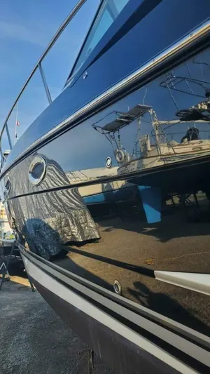  Yacht Photos Pics 2013 Monterey 340 Sport Yacht with sleek black hull, docked under clear blue sky.