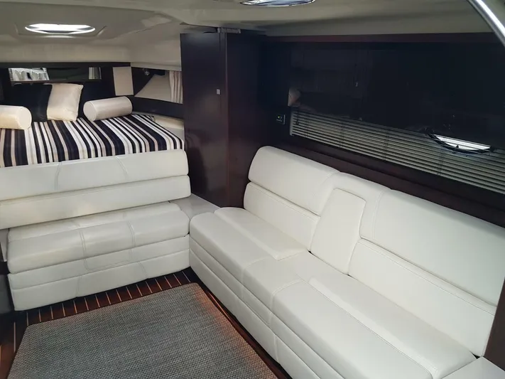  Yacht Photos Pics Interior of 2013 Monterey 340 Sport Yacht with white leather seating and striped bedding.