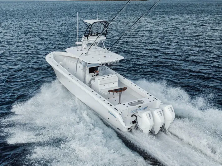 Southpaw Yacht Photos Pics 2015 Bahama 41' boat cruising on open water with triple outboard engines.