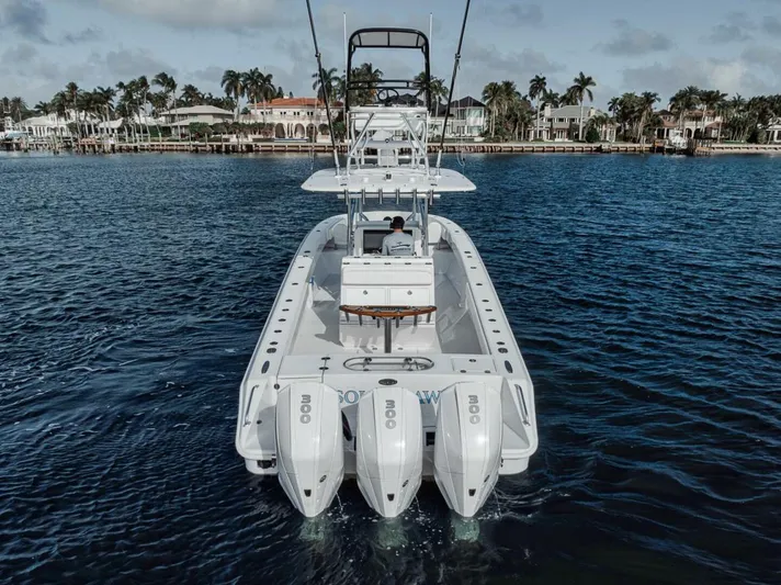 Southpaw Yacht Photos Pics 2015 Bahama 41' boat with triple engines on calm water, coastal homes in background.