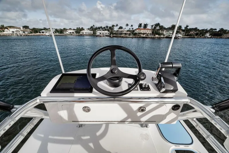 Southpaw Yacht Photos Pics 2015 Bahama 41' boat helm with steering wheel and controls on calm water.
