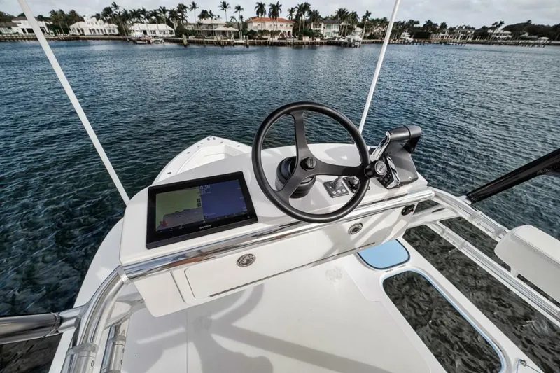 Southpaw Yacht Photos Pics 2015 Bahama 41' boat helm with steering wheel and navigation screen on calm water.