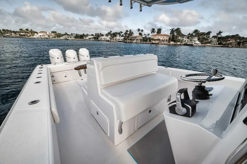 Southpaw Yacht Photos Pics 2015 Bahama 41' boat with triple engines, white seating, and steering wheel on calm water.