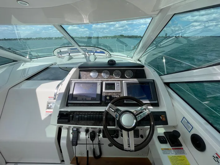  Yacht Photos Pics Helm of 2010 Sea Ray 450 Sundancer with navigation screens and steering wheel, overlooking ocean.