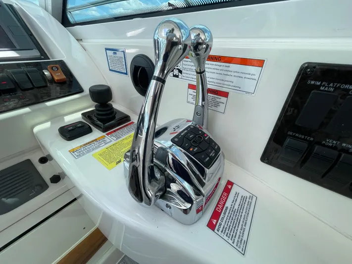  Yacht Photos Pics Control panel of a 2010 Sea Ray 450 Sundancer boat with throttle levers and warning labels.