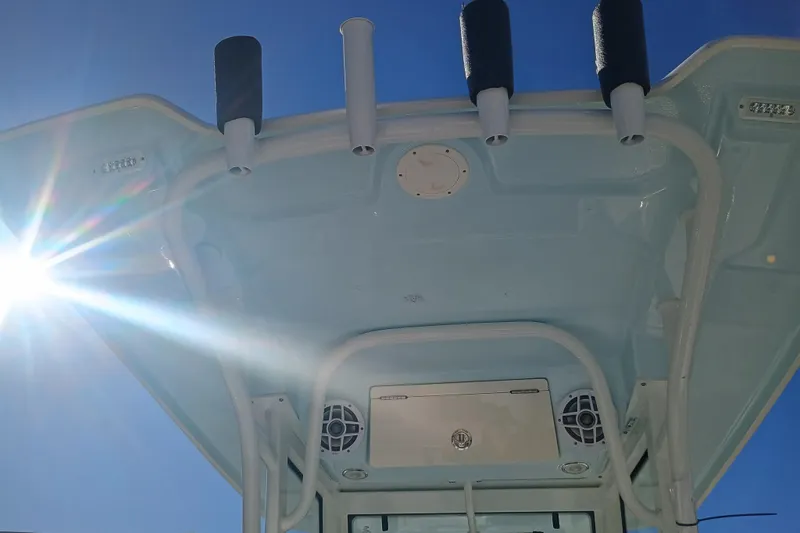 250-118 Yacht Photos Pics 2026 Robalo R250 Center Console boat roof with rod holders and sunlight.