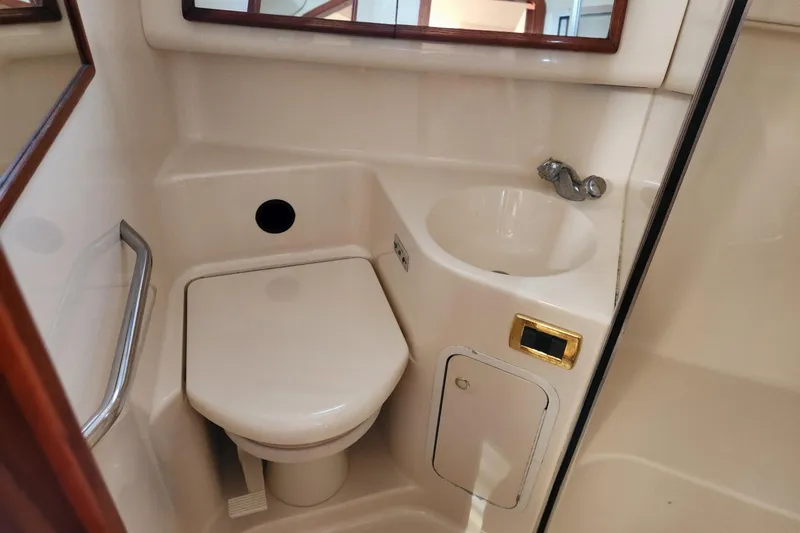 Four Seas Yacht Photos Pics 2001 Sea Ray 400 Sedan Bridge bathroom with toilet, sink, and mirror.