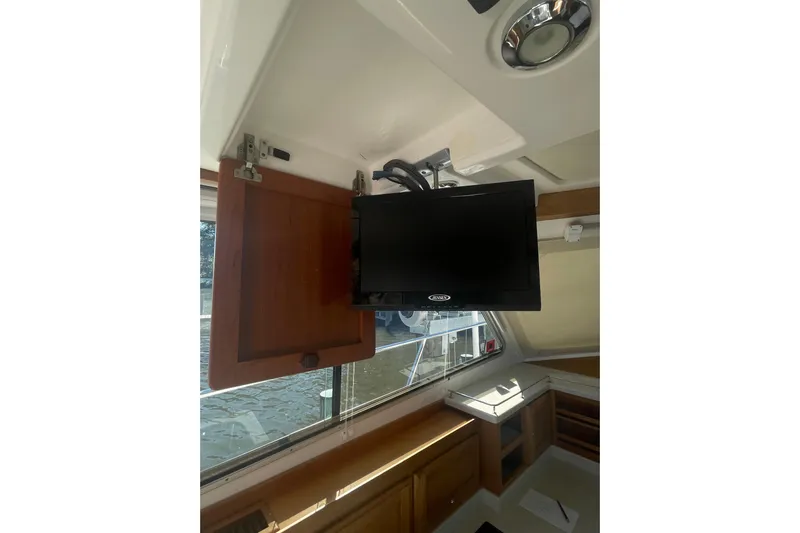 Selah Yacht Photos Pics Interior of 2012 Back Cove 37 boat with mounted TV and wooden cabinetry.