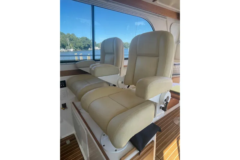 Selah Yacht Photos Pics Luxurious beige seats inside a 2012 Back Cove 37 boat, with scenic water view.