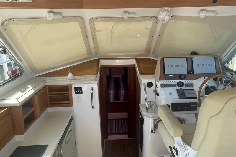 Selah Yacht Photos Pics 2012 Back Cove 37 yacht helm with Garmin navigation, beige seating, and wooden cabinetry.