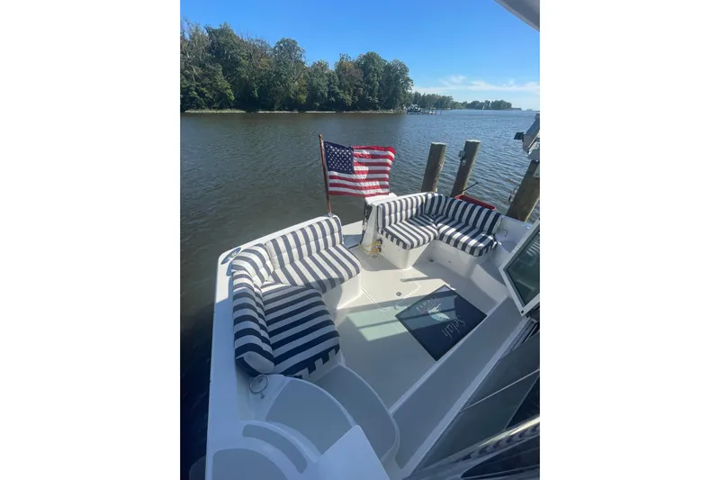 Selah Yacht Photos Pics 2012 Back Cove 37 boat with striped seating and American flag on a calm river.
