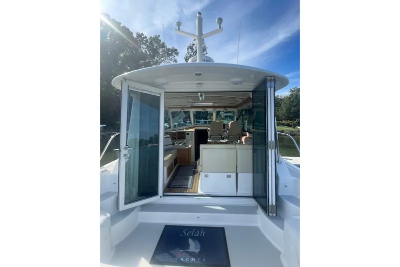 Selah Yacht Photos Pics 2012 Back Cove 37 yacht with open cabin doors, docked in a serene setting.