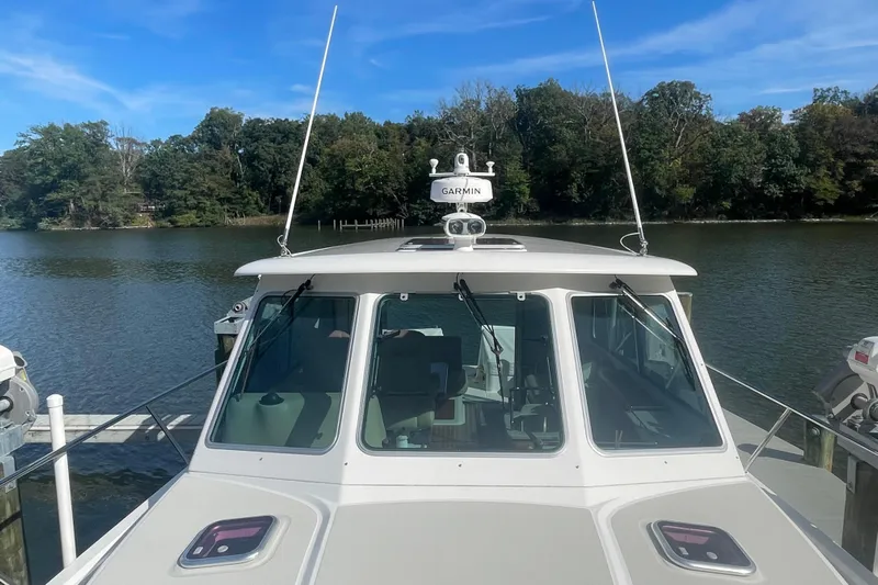 Selah Yacht Photos Pics 2012 Back Cove 37 boat docked on a serene lake with lush trees in the background.