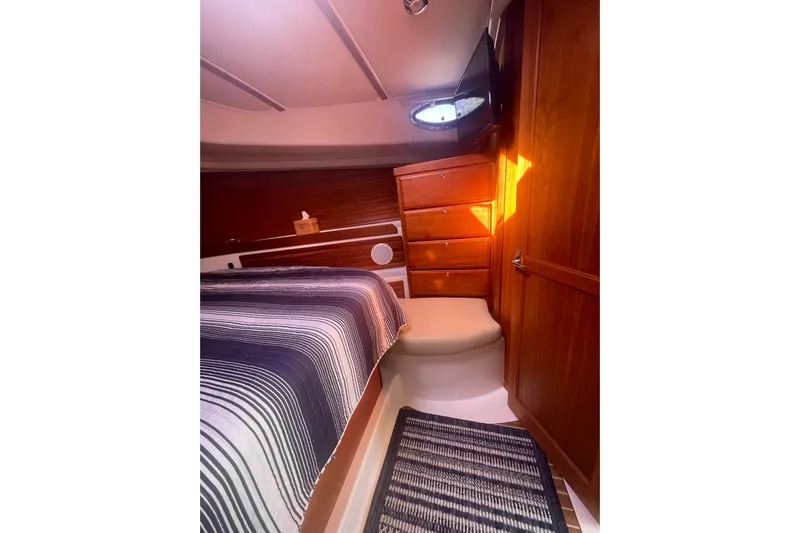 Selah Yacht Photos Pics Cozy cabin interior of 2012 Back Cove 37 yacht with striped bedding and wooden cabinetry.