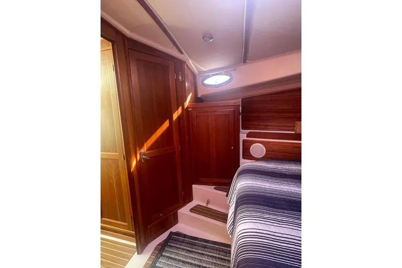 Selah Yacht Photos Pics 2012 Back Cove 37 cabin interior with wooden cabinetry and striped bedding.