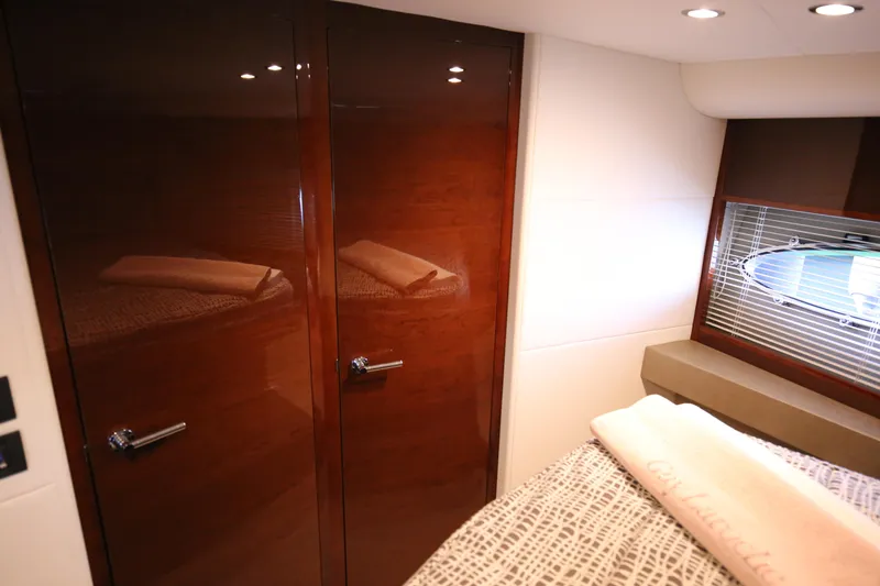  Yacht Photos Pics Luxurious interior of 2015 Princess V48 yacht with polished wood finish and cozy bedding.