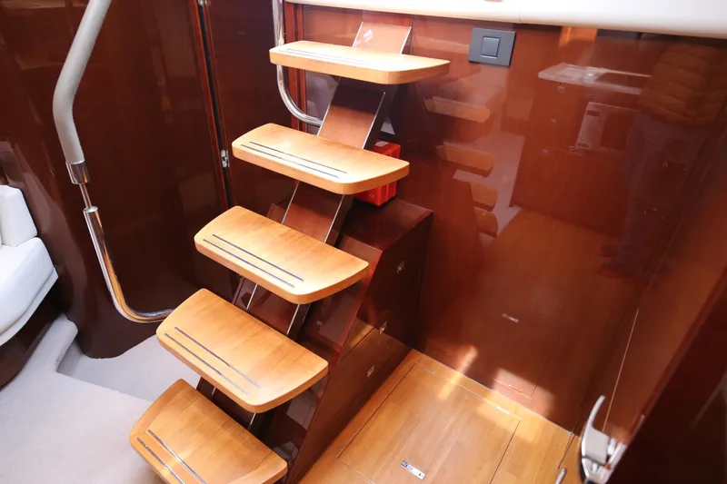  Yacht Photos Pics Staircase inside 2015 Princess V48 yacht with wooden steps and sleek design.