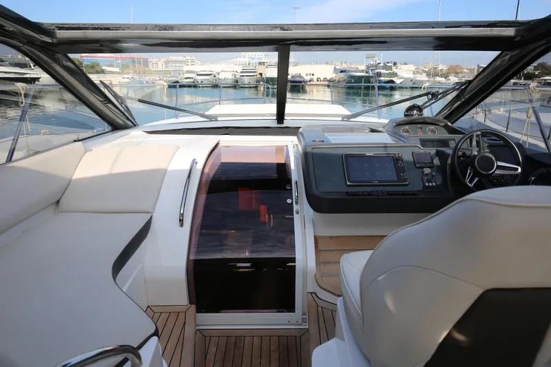  Yacht Photos Pics Interior view of 2015 Princess V48 yacht cockpit with modern controls and seating.