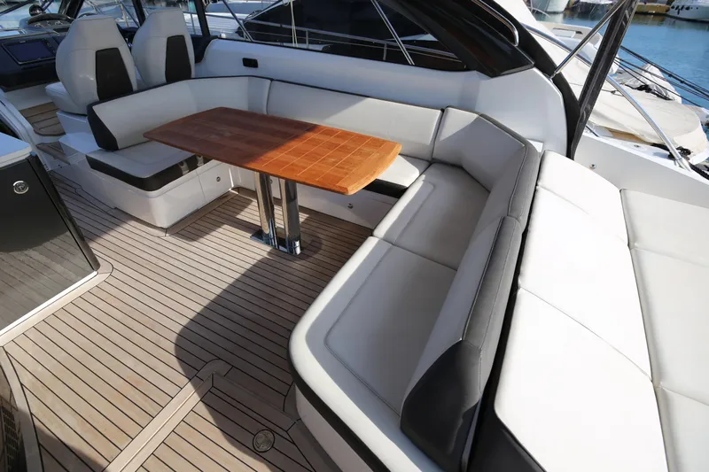  Yacht Photos Pics Luxurious seating area on 2015 Princess V48 yacht with wooden table and cushioned seats.
