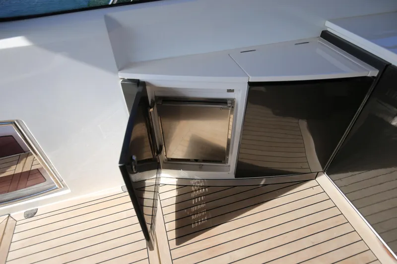  Yacht Photos Pics Open mini fridge on 2015 Princess V48 yacht deck with wooden flooring.