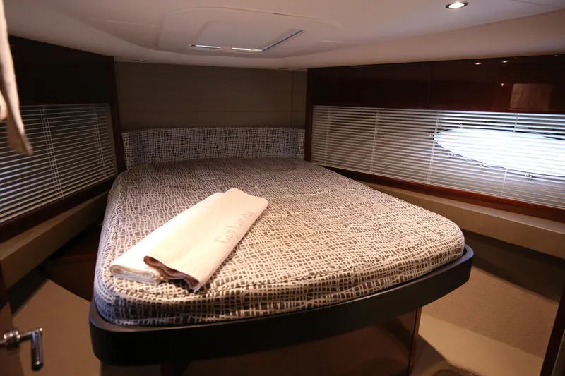  Yacht Photos Pics Luxurious cabin interior of 2015 Princess V48 yacht with cozy bed and ambient lighting.