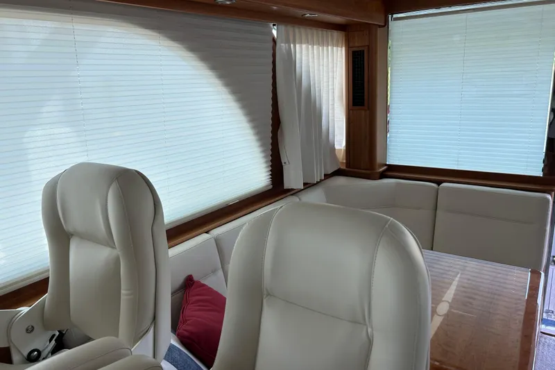  Yacht Photos Pics Interior of 2022 Sabre 45 Salon Express yacht with white leather seating and wooden accents.