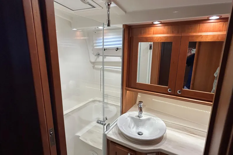  Yacht Photos Pics Luxurious bathroom in 2022 Sabre 45 Salon Express yacht with modern fixtures and wood accents.
