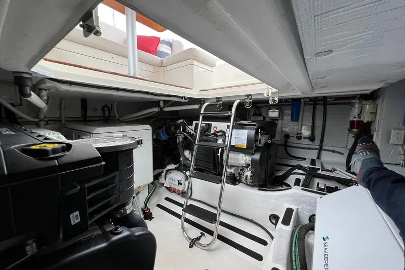  Yacht Photos Pics Engine room of 2022 Sabre 45 Salon Express yacht, showcasing mechanical components and seating area.