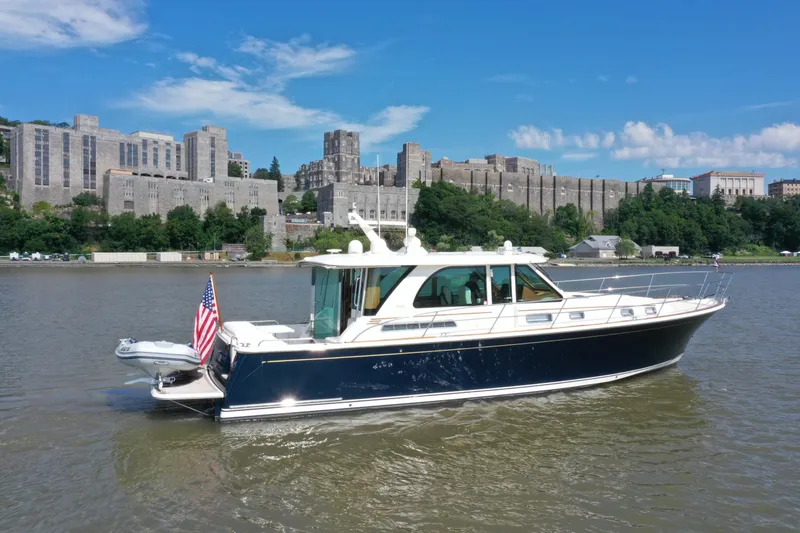  Yacht Photos Pics 2022 Sabre 45 Salon Express yacht cruising on a river with historic buildings in the background.