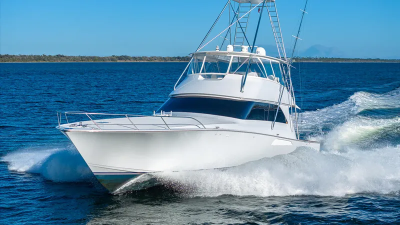 First Bite Yacht Photos Pics A 2004 Viking 2005 yacht cruising swiftly on open water under a clear blue sky.