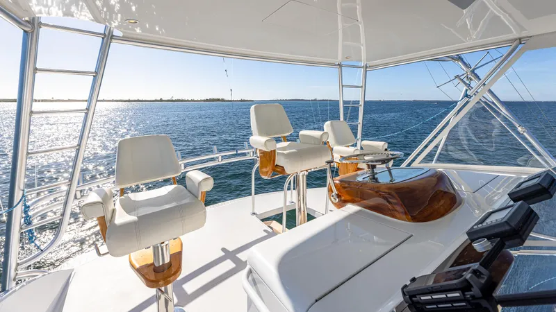 First Bite Yacht Photos Pics Luxurious Viking 2005 yacht helm with ocean view, featuring sleek white seating and polished wood accents.