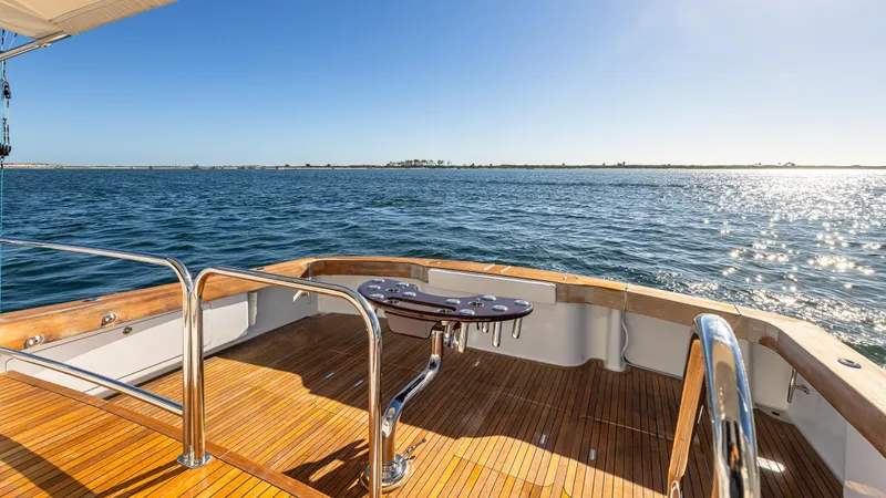 First Bite Yacht Photos Pics Luxury Viking 2005 yacht deck with ocean view, featuring polished wood and stainless steel railings.