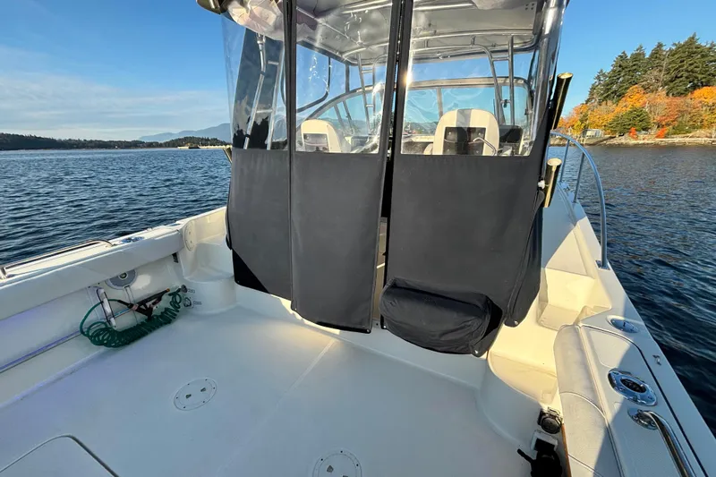  Yacht Photos Pics 2006 Pursuit 3070 Offshore boat on calm water, featuring spacious deck and clear canopy.