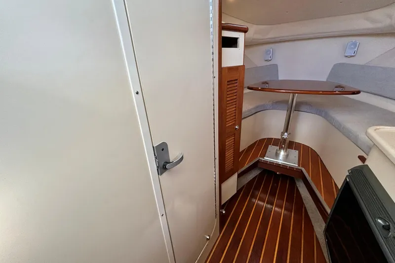  Yacht Photos Pics 2006 Pursuit 3070 Offshore cabin interior with wood flooring and table.