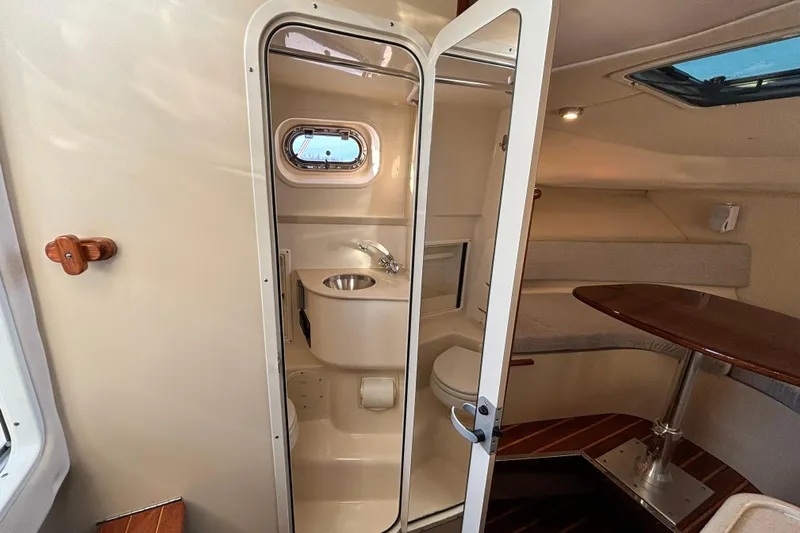  Yacht Photos Pics Interior of 2006 Pursuit 3070 Offshore boat, featuring compact bathroom and seating area.