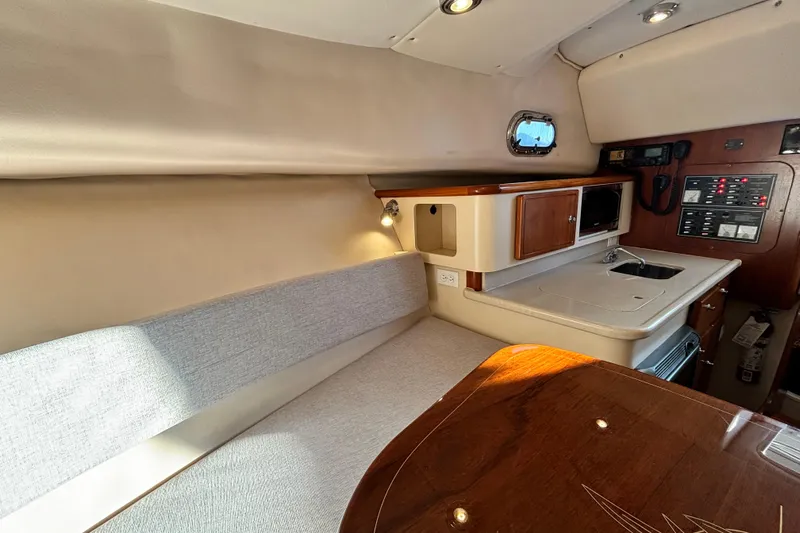  Yacht Photos Pics 2006 Pursuit 3070 Offshore cabin interior with kitchenette and seating area.