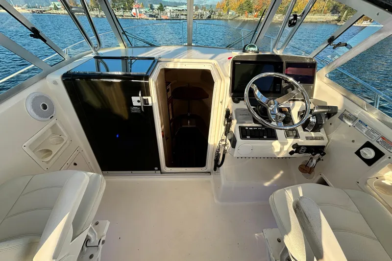  Yacht Photos Pics 2006 Pursuit 3070 Offshore boat cockpit with steering wheel, controls, and cabin entrance.