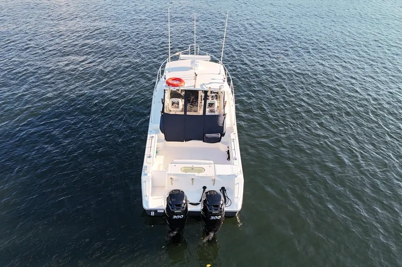  Yacht Photos Pics 2006 Pursuit 3070 Offshore boat with dual engines on calm water.