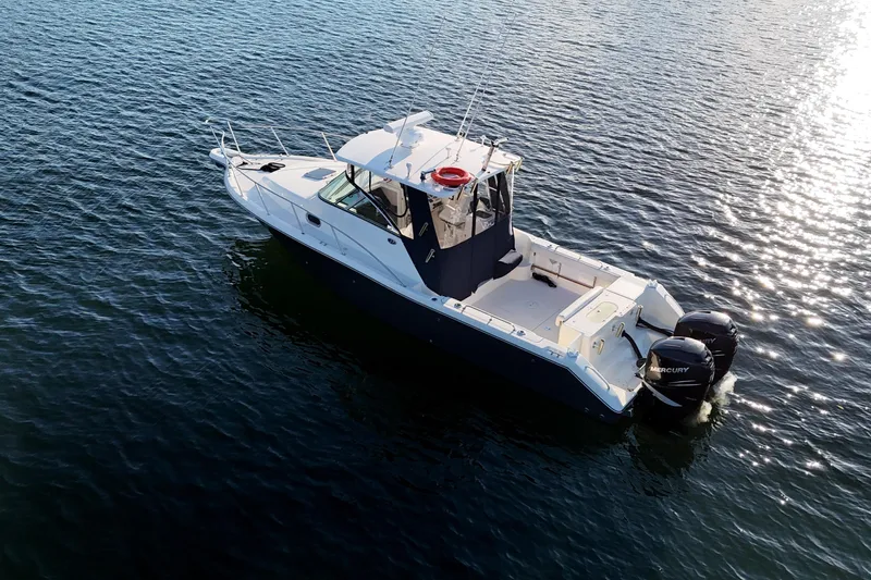  Yacht Photos Pics 2006 Pursuit 3070 Offshore boat on calm water, featuring dual Mercury engines.