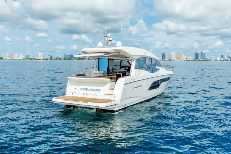  Yacht Photos Pics 2018 Prestige 520S yacht cruising near a city skyline under a cloudy sky.