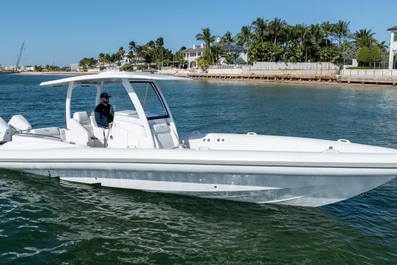  Yacht Photos Pics 2025 Airship 340 boat cruising on a sunny day near a tropical shoreline.